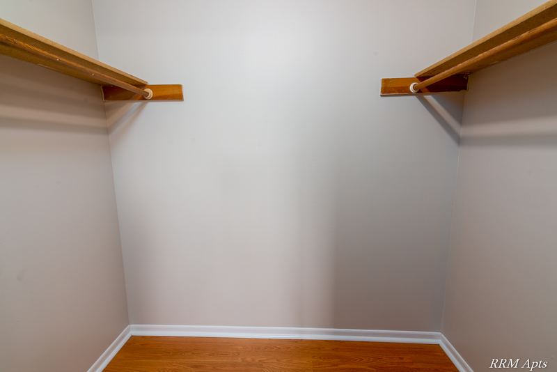 Closet with wood floor and hanging rods with shelves on two walls, Pioneer Court apartment 918-3C