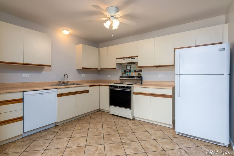 Kitchen with white oak-trimmed cabinets, white dishwasher, stove and refrigerator, Pioneer Court apartment 918 3F