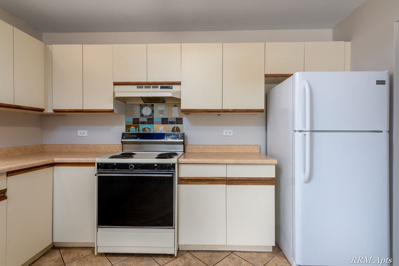 Kitchen with white oak-trimmed cabinets, black-and-white stove and a white refrigerator, Pioneer Court apartment 918 3F