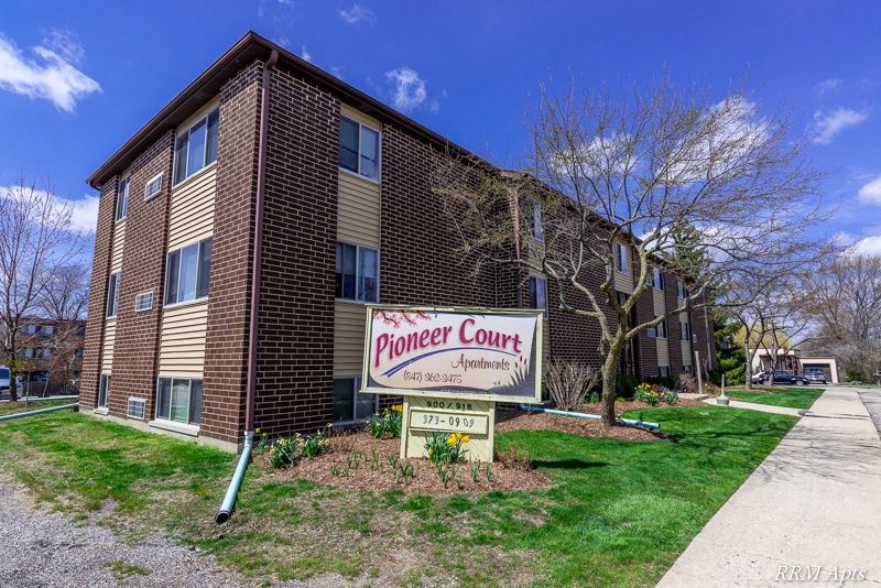 Three-story brick and siding apartment building with the Pioneer Court Apartments sign