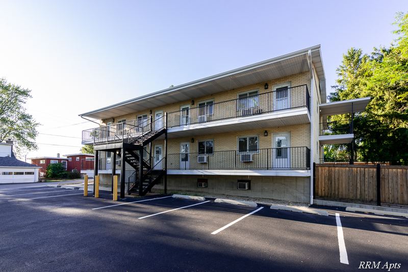 Two-story brick apartment building with exterior stairs, balconies and parking lot at Pistakee Road