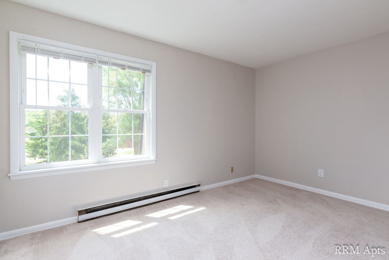 Empty room with beige carpet, double window and a baseboard heater, Prairie Ridge apartment 9716 2B