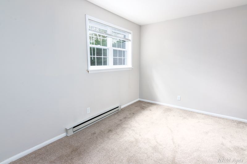 Empty room with beige carpet, one window and a baseboard heater, Prairie Ridge apartment 9716 GA