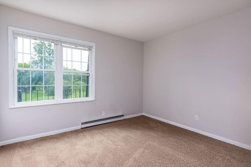 Empty room with beige carpet, one window and a baseboard heater under it, Prairie Ridge apartment 9718 2C