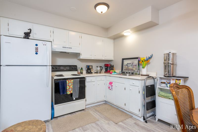 Kitchen with white cabinets, white refrigerator and stove, and light wood-look floor, Prairie Ridge apartment 9718 GC