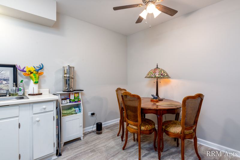 Dining area with round wood table and chairs, stained-glass lamp and ceiling fan, Prairie Ridge apartment 9718 GC