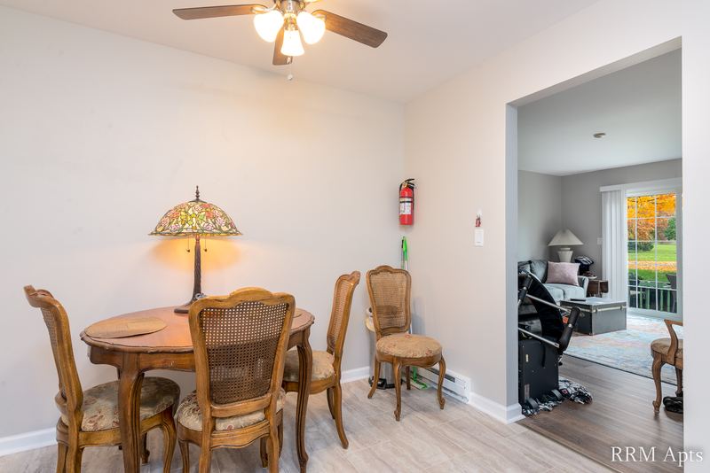 Dining area with round table and chairs, ceiling fan and a doorway to the living room, Prairie Ridge apartment 9718 GC