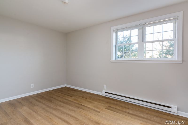 Empty room with wood floor, double window and a baseboard heater, Prairie Ridge apartment 9806 GA