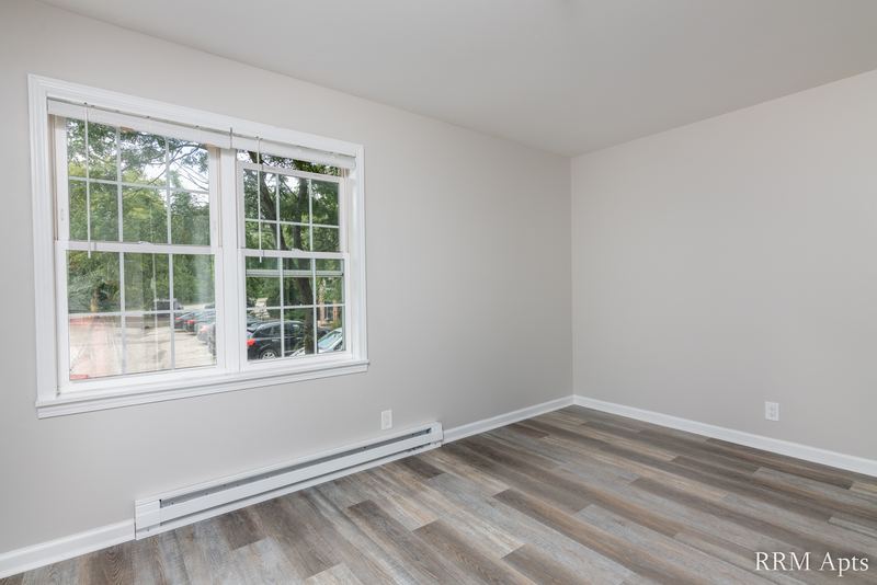 Empty room with gray wood-look floor, double window and a baseboard heater, Prairie Ridge apartment 9808-1D