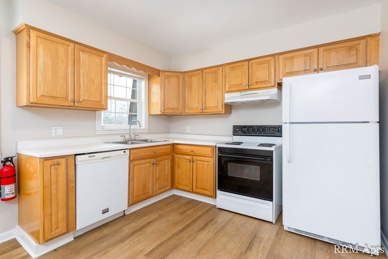 Kitchen with light oak cabinets, white refrigerator, stove, dishwasher and wood floor, Prairie Ridge apartment 9812 2D