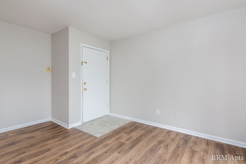 Entry area with front door and wood-look floor, Prairie Ridge apartment GC
