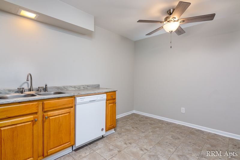 Kitchen with oak cabinets, double sink, dishwasher and ceiling fan, Prairie Ridge apartment GC