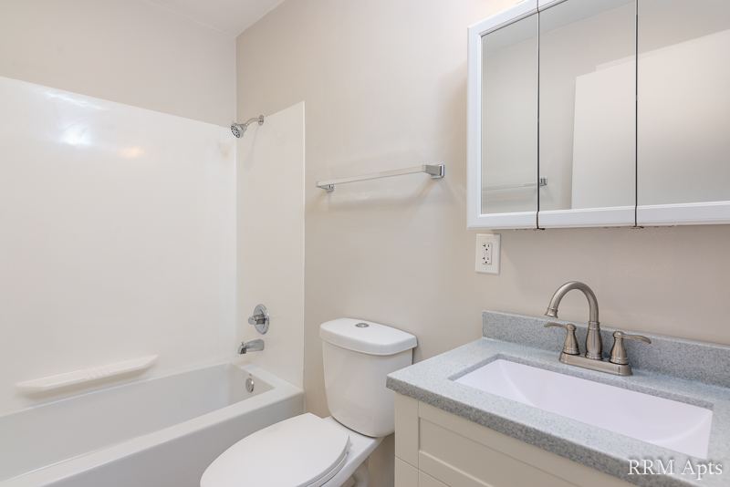 Bathroom with tub and shower, toilet, vanity and mirrored medicine cabinet, Prairie Ridge apartment GC