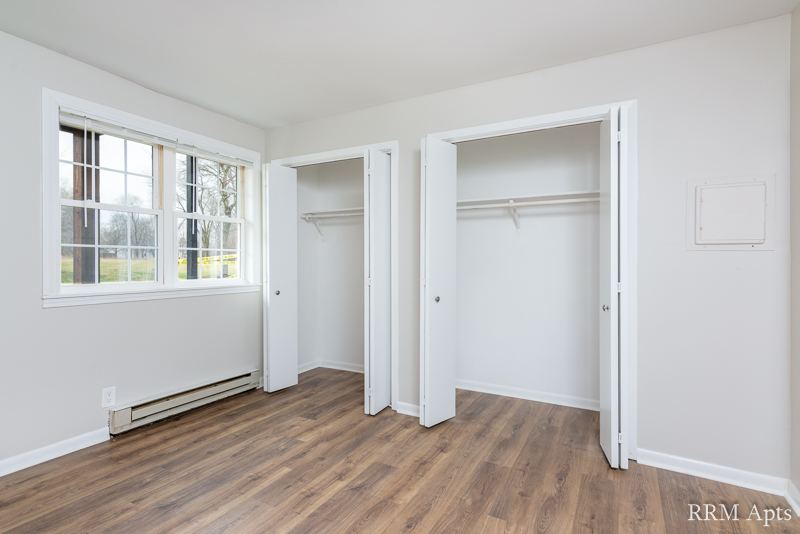 Bedroom with windows and two open closets, Prairie Ridge apartment GC