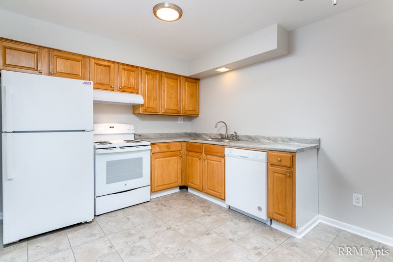 Kitchen with oak cabinets, white refrigerator, electric stove, dishwasher and tile floor, Prairie Ridge apartment GC
