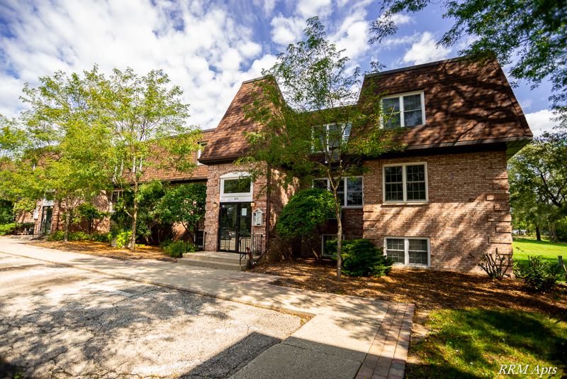 Three-story brick apartment building with mansard roof and trees at Prairie Ridge, Richmond