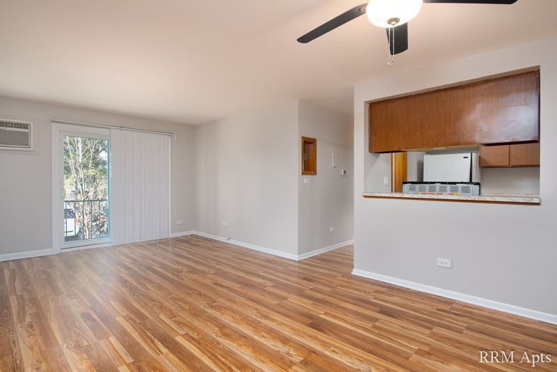 Living room with hardwood floor, ceiling fan, sliding door to balcony and pass-through to the kitchen, Slusser Street apartment 3