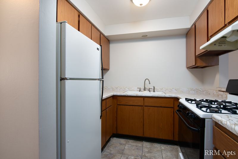 Kitchen with oak cabinets, stainless refrigerator and gas stove, Slusser Street apartment 3
