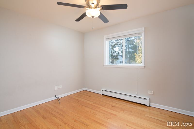 Bedroom with ceiling fan, window and hardwood floor, Slusser Street apartment 3