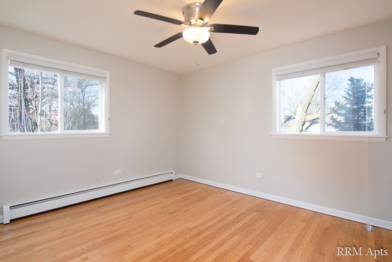 Bedroom with two windows, ceiling fan and hardwood floor, Slusser Street apartment 3
