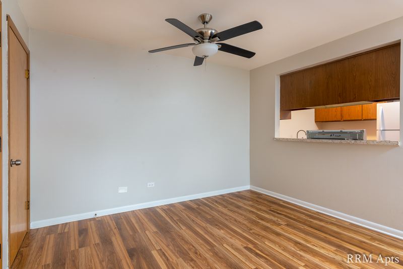 Dining area with wood floor, ceiling fan, wood door and a pass-through to the kitchen, Slusser Street apartment 5