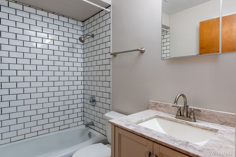 Bathroom with white subway tile tub surround, granite-look vanity top and medicine cabinet, Slusser Street apartment 7