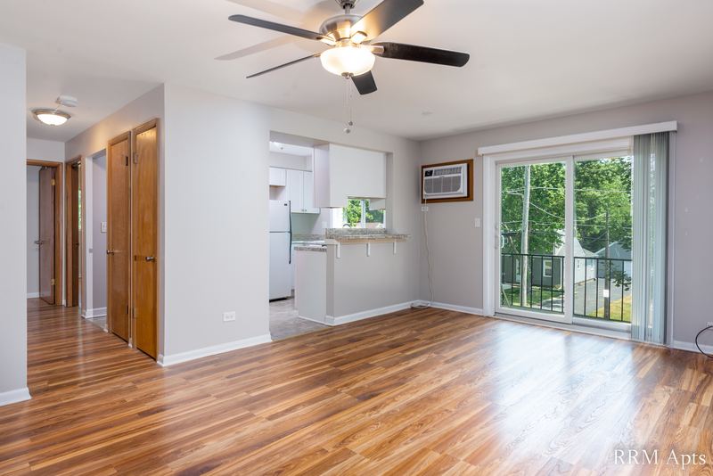 Living room with wood floor, ceiling fan, kitchen pass-through and sliding glass balcony door, Slusser Street apartment 8