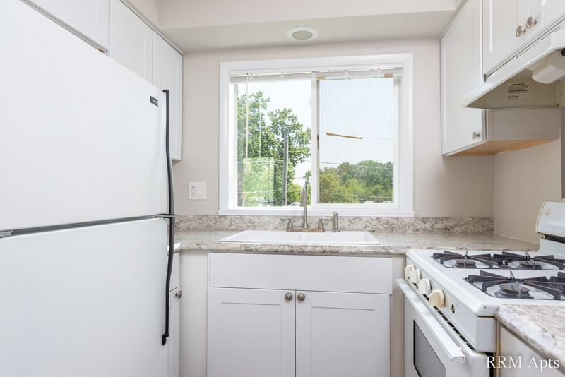 Kitchen with white cabinets, white refrigerator, gas stove and window over the sink, Slusser Street apartment 8