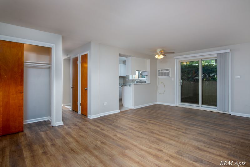 Living room with wood floor, ceiling fan, entry closet, kitchen pass-through and sliding door, Slusser Street apartment 9