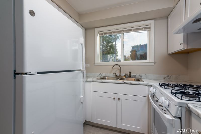 Kitchen with white cabinets, white refrigerator, gas stove and window over the sink, Slusser Street apartment 9