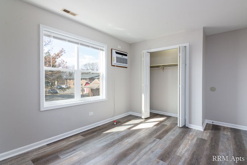 Bedroom with window, wall air conditioner and open closet, South Slusser apartment 4