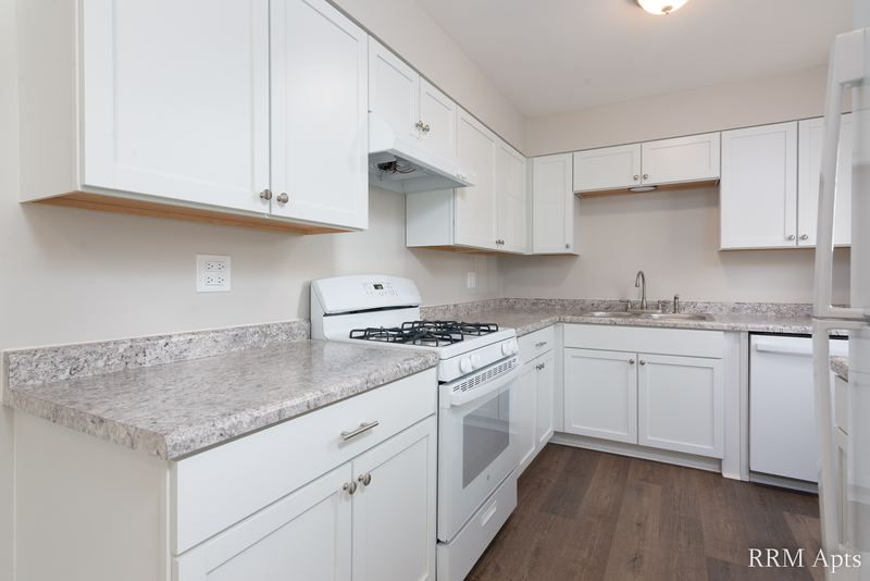 Kitchen with white cabinets, white gas stove, white dishwasher and granite-look counter, South Slusser apartment 430