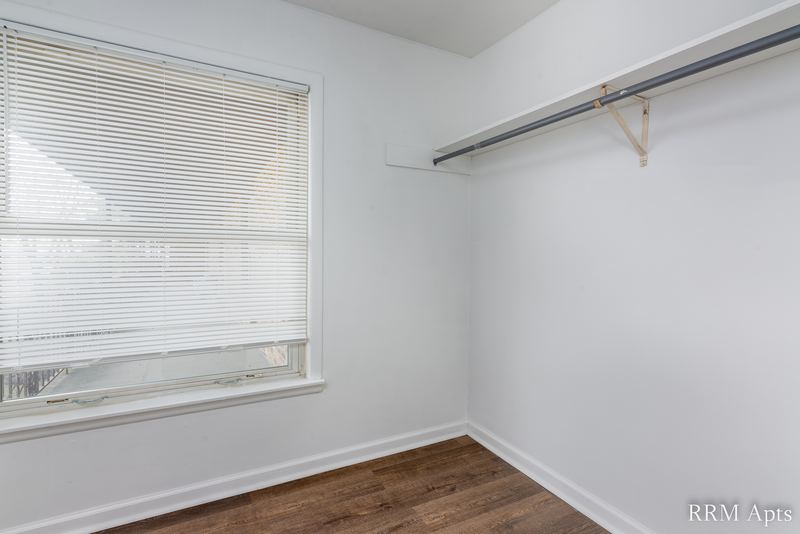 Closet with wood floor, hanging rod and window with white blinds, South Slusser apartment 430