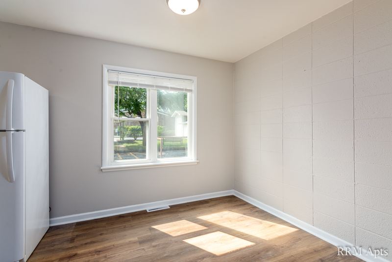 Dining area with window, white refrigerator and wood-look floor, South Slusser apartment 434