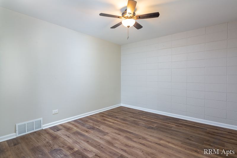 Bedroom with ceiling fan and wood-look floor, South Slusser apartment 434