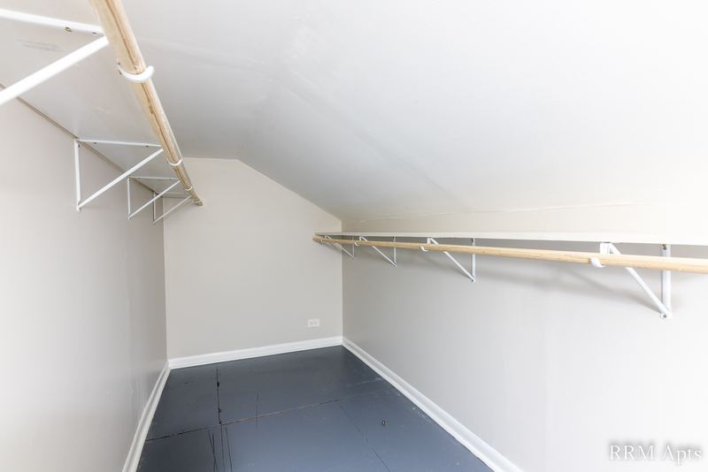 Closet with sloped ceiling, hanging rods and dark painted floor, South Slusser apartment 51 St Paul