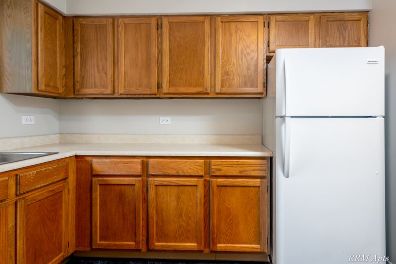 Kitchen corner with oak cabinets, white refrigerator and light laminate counter, South Slusser apartment 440-6