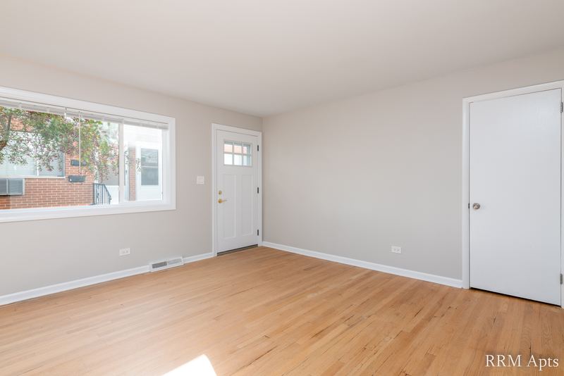 Living room with wood floor, window, white entry door and white closet door, Westerfield Place apartment 143 B