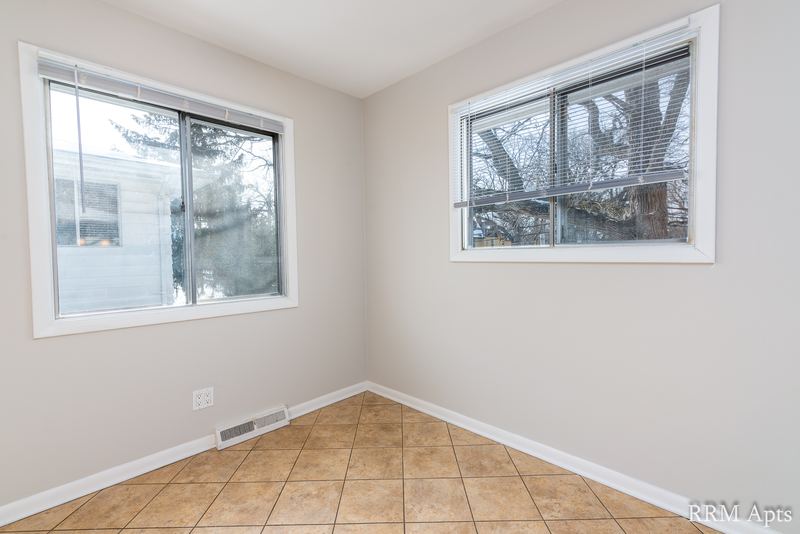 Dining area with beige tile floor and two windows facing trees, Westerfield Place apartment 143 C