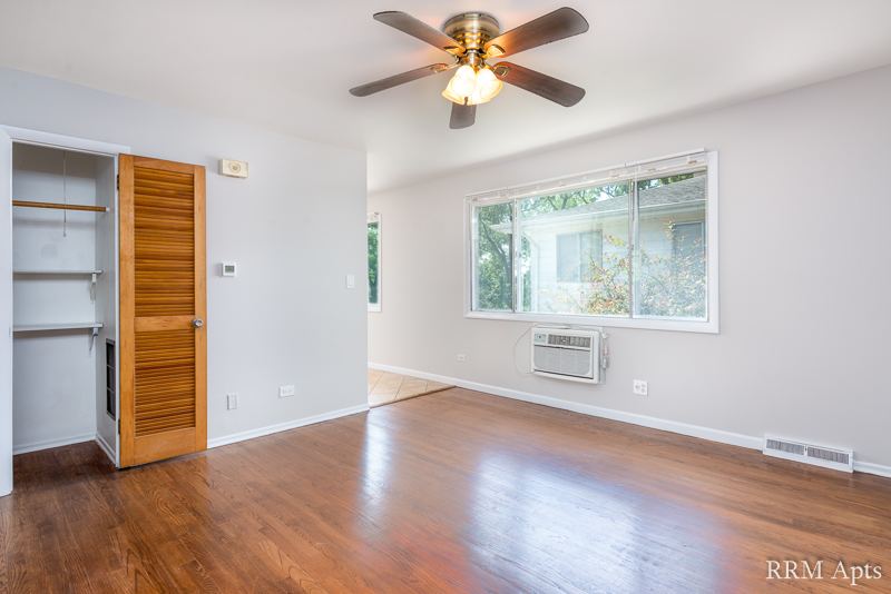 Living room with hardwood floor, ceiling fan, window air conditioner and coat closet, Westerfield Place apartment 145D