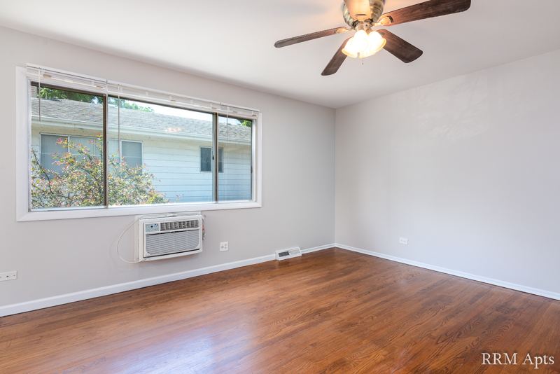 Living room with hardwood floor, ceiling fan and window air conditioner, Westerfield Place apartment 145D