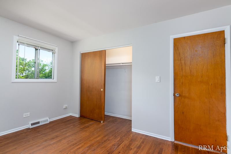 Bedroom with hardwood floor, window and open closet, Westerfield Place apartment 145D