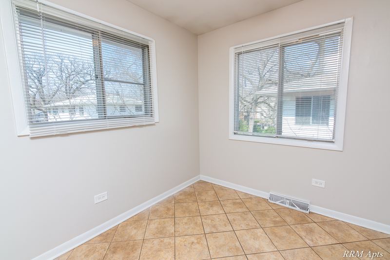 Dining area with beige tile floor and two windows facing neighboring houses, Westerfield Place apartment 147 C