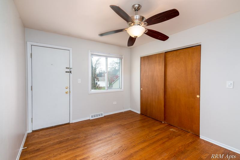 Bedroom with wood floor, ceiling fan, white door, window and wood sliding-door closet, Westerfield Place apartment 147 C