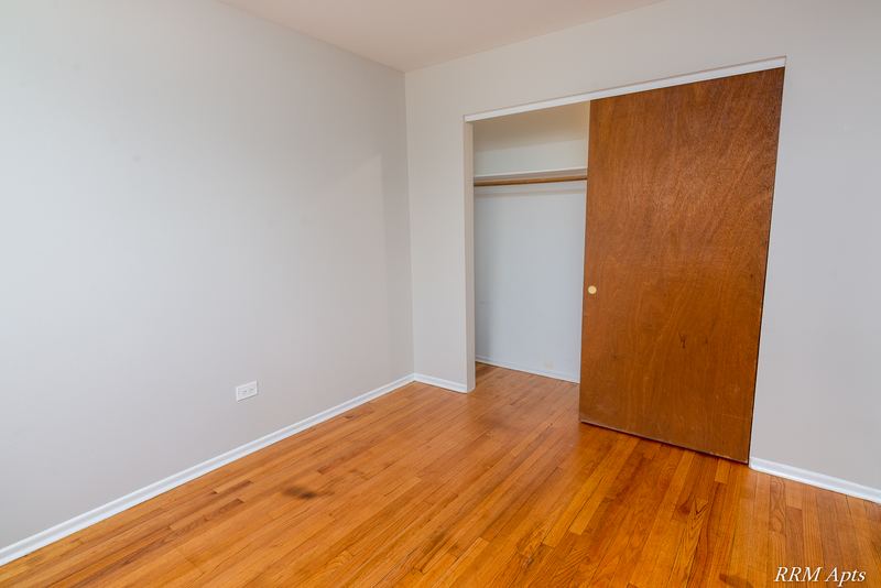 Bedroom with wood floor, gray walls and open closet with wood sliding door, Westerfield Place apartment 147 D