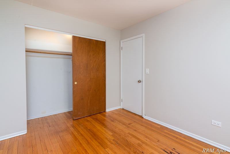 Bedroom with wood floor, open closet with wood sliding door and white door, Westerfield Place apartment 147 D