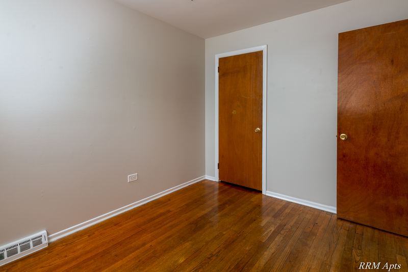 Bedroom with wood floor, two wood doors and baseboard radiator, Westerfield Place apartment 147B