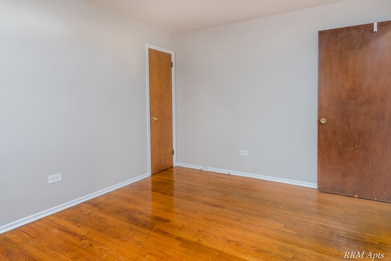 Bedroom with wood floor, gray walls, open wood door and doorway to the hall, Westerfield Place apartment 147B