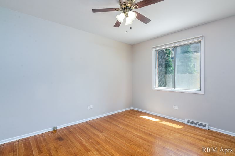 Bedroom with wood floor, ceiling fan, window on the right and baseboard heater, Westerfield Place apartment 149 A