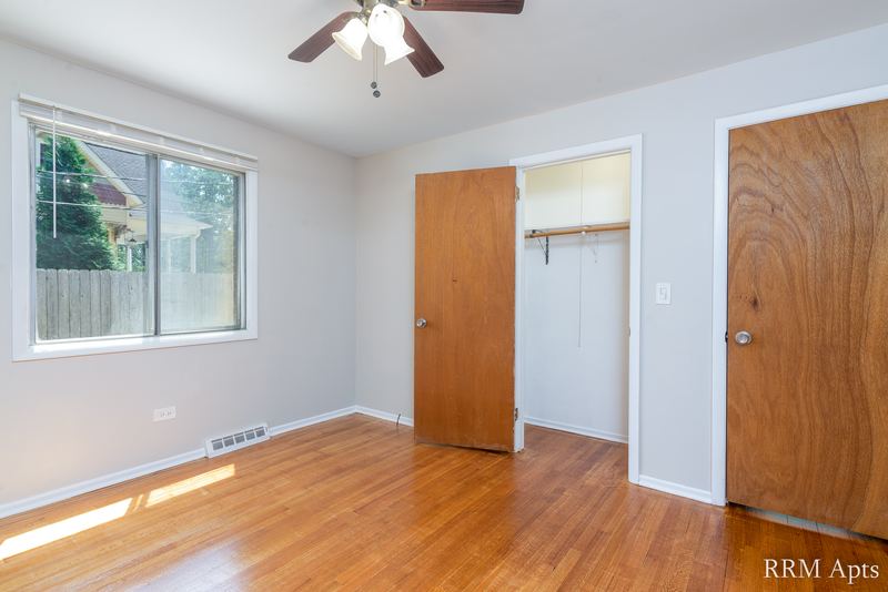 Bedroom with wood floor, ceiling fan, window, open closet and wood door, Westerfield Place apartment 149 A
